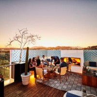 wide shot of families enjoying dinner on rooftop at resort during sunset - travel stock pictures, royalty-free photos & images