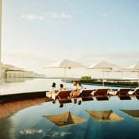 wide shot of family hanging out on lounge chairs by pool at resort - travel stock pictures, royalty-free photos & images