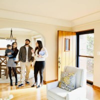 wide shot of family looking at home for sale with real estate agent - home decoration photos et images de collection