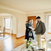 wide shot of family looking at sales sheet in home for sale - home decoration stockfoto's en -beelden