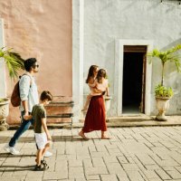 wide shot of family walking down street while exploring town during vacation - travel stock-fotos und bilder