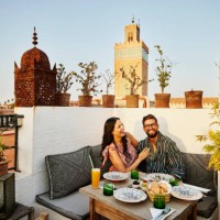 wide shot of laughing couple dining at rooftop restaurant in marrakech - travel stock pictures, royalty-free photos & images