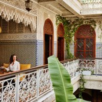 wide shot of mature woman working on laptop in riad during vacation - travel stock pictures, royalty-free photos & images
