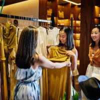wide shot of mother and daughters shopping for clothes in boutique - fashion stock pictures, royalty-free photos & images