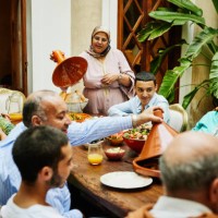 wide shot of multigenerational family serving food during celebration - food stock pictures, royalty-free photos & images