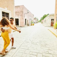 wide shot of smiling couple dancing in street while exploring town during vacation - travel stock pictures, royalty-free photos & images