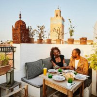 wide shot of smiling couple dining at rooftop restaurant in marrakech - travel stock pictures, royalty-free photos & images