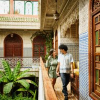 wide shot of smiling couple holding hands and walking through riad - travel stock pictures, royalty-free photos & images