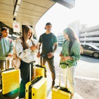 wide shot of smiling family waiting at airport curb for rideshare pickup - travel stock pictures, royalty-free photos & images
