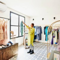 wide shot of woman taking photo of coat while shopping in boutique - fashion stock pictures, royalty-free photos & images