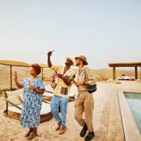 wide shot smiling friends taking selfies by pool at desert camp - travel stock pictures, royalty-free photos & images