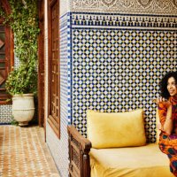 wide shot smiling woman relaxing in alcove of ornately decorated riad - travel stock pictures, royalty-free photos & images