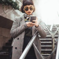 winter portrait of a young woman in the city texting - fashion stock pictures, royalty-free photos & images