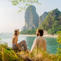 woman and man sitting on cliff on the background of railey bay - travel stock pictures, royalty-free photos & images