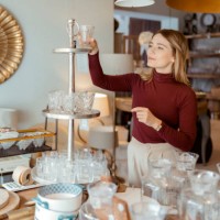 woman arranging home accessories in home decor store - home decoration stock pictures, royalty-free photos & images