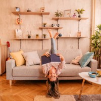 woman at home lying on sofa and reading book - home decoration stock pictures, royalty-free photos & images