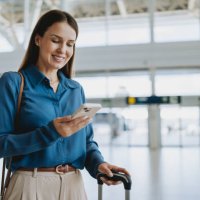 woman at the airport holding smartphone - travel stock pictures, royalty-free photos & images
