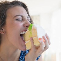 woman biting piece of cake - junk food stock pictures, royalty-free photos & images