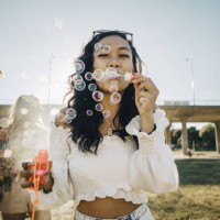 woman blowing soap bubbles while friends playing ukulele during music event - fashion stock pictures, royalty-free photos & images