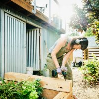 woman building raised garden beds in backyard on summer afternoon - home decoration stock pictures, royalty-free photos & images