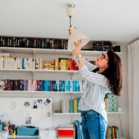 woman changing bulb in house - home decoration stock pictures, royalty-free photos & images