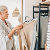 woman choosing dress in front of mirror. - fashion stock pictures, royalty-free photos & images