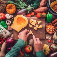 woman chopping squash on a table full of fresh autumnal vegetables - food stock pictures, royalty-free photos & images