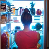 woman contemplating midnight snack late night with open refrigerator - food stock pictures, royalty-free photos & images