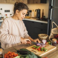 woman cutting fresh organic vegetables for salad on kitchen. sustainable lifestyle - food stock pictures, royalty-free photos & images