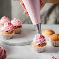 woman doing icing on cupcakes with pink whipped cream - home decoration stock pictures, royalty-free photos & images