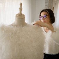 woman dressmaker putting a dress on a mannequin - fashion week stock-fotos und bilder