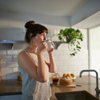 woman drinking from mug in zero waste kitchen. - coffee stock pictures, royalty-free photos & images