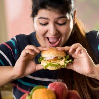 woman eating a fast food burger - junk food stock pictures, royalty-free photos & images