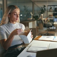 woman, eating and chinese food in office at night, working or employee reading computer, research and planning project. person, thinking and hungry for asian dinner and takeaway on desk in workplace - junk food stock pictures