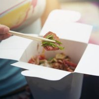 woman eating asian fast food from a cardboard box - junk food stock pictures, royalty-free photos & images