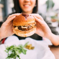 woman eating beef burger - food stock pictures, royalty-free photos & images