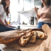 woman eating empanada at home - junk food stock pictures, royalty-free photos & images