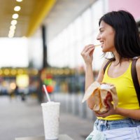 woman eating fast food in the city - junk food stock pictures, royalty-free photos & images