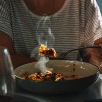 woman eating fusilli pasta with bolognese sauce - food fotografías e imágenes de stock