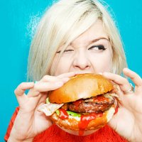 woman eating hamburger - junk food stock pictures, royalty-free photos & images