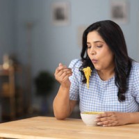 woman eating hot and spicy noodle at home stock photo - junk food stock pictures, royalty-free photos & images