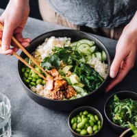 woman eating poke salad with chopsticks - food stockfoto's en -beelden