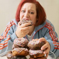 woman eating stacks of donuts - junk food stock pictures, royalty-free photos & images