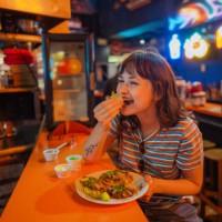 woman eating taco in a bar - food stock pictures, royalty-free photos & images