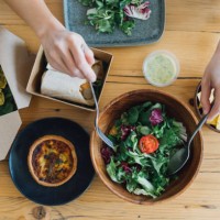 woman eating takeaway vegetarian food at home - junk food stock pictures, royalty-free photos & images