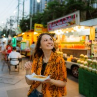 woman eating thai pancakes (roti) on night market in bangkok during her vacation - food stock pictures, royalty-free photos & images