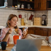 woman enjoying food home delivery and using smart phone - junk food stock pictures, royalty-free photos & images