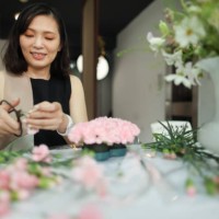 woman focused on flower arrangement creation - garden decoration stock pictures, royalty-free photos & images