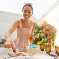 woman grabbing food from a garden table - garden decoration stockfoto's en -beelden