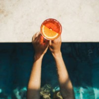 woman hands holding spritz cocktail on poolside close-up. leisure and relaxation concept, cold summer drink - food stock pictures, royalty-free photos & images